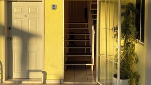 A yellow building with a white door, a staircase, and a welcome sign. - Hotel Posada Los Olivos Los Mochis (Los Mochis)