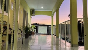 A covered outdoor area with tiled flooring, potted plants, and a railing. - Hotel Posada Los Olivos Los Mochis (Los Mochis)