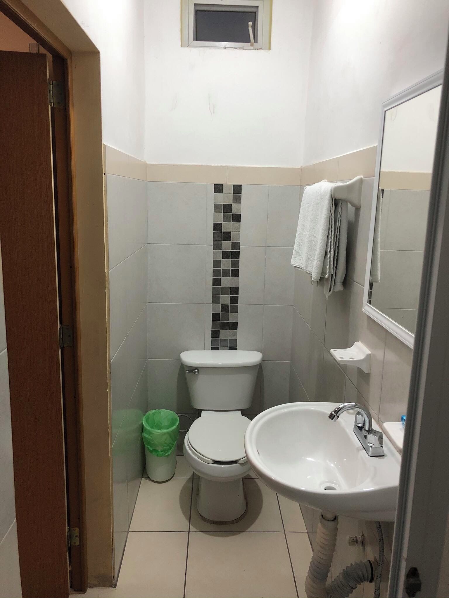 Un baño pequeño con inodoro, lavabo y espejo.