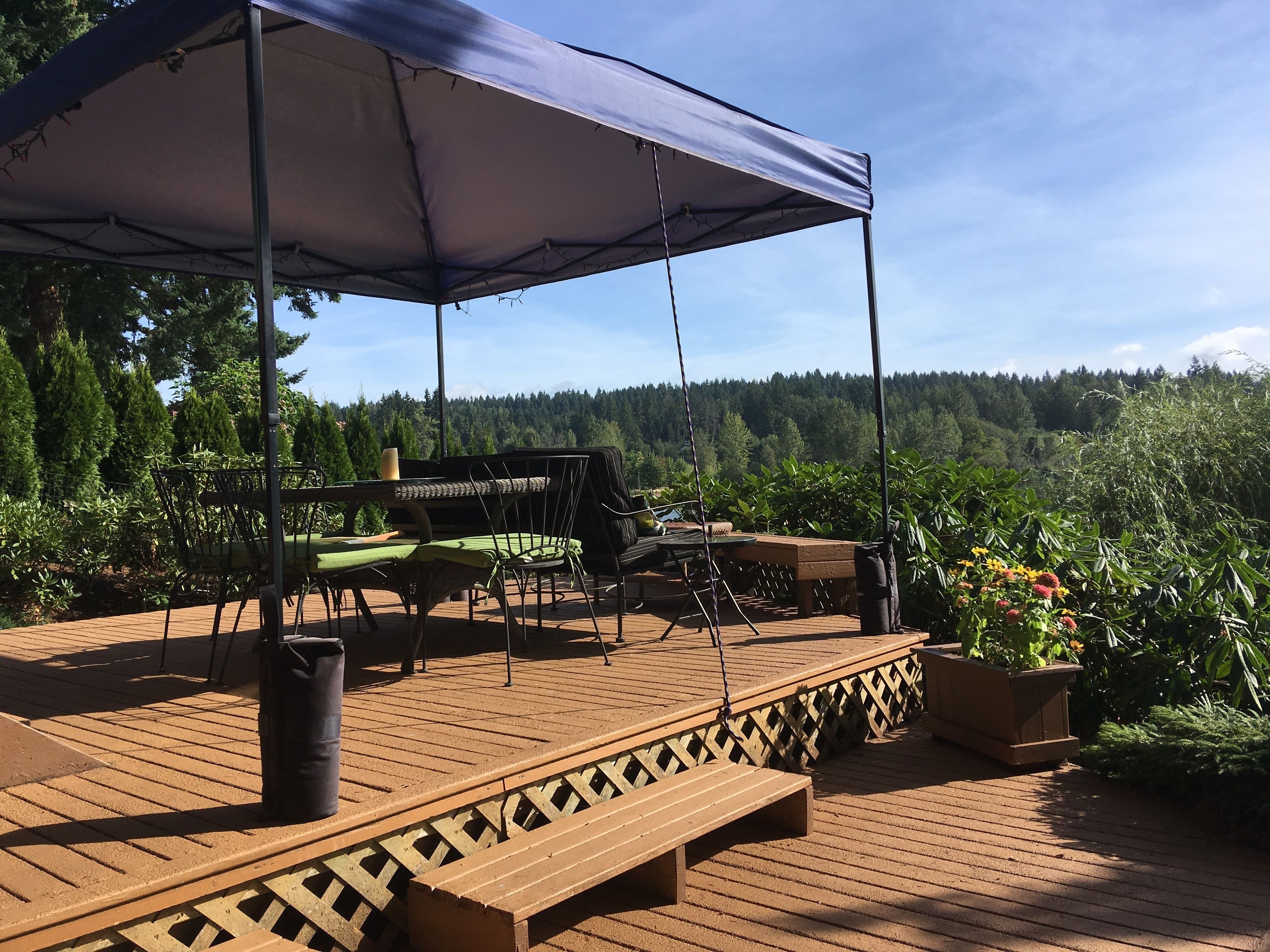 Terraza exterior con zona de estar cubierta, una mesa y un banco.