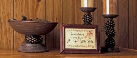 A wooden wall with a framed sign and two candles on stands.