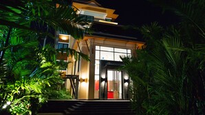 A modern two-story building with a balcony, surrounded by lush greenery. - Visa Hotel Hua Hin (Hua Hin)