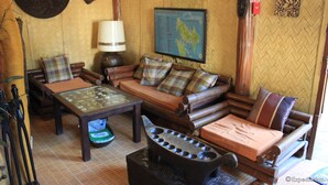 A cozy room with a sofa set, a coffee table, a lamp, and a map on the wall. - Darayonan Lodge (Coron)
