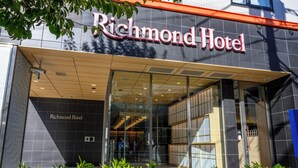 L’extérieur de l’hôtel Richmond présente un design moderne, avec une grande entrée vitrée et une enseigne au-dessus de la porte.