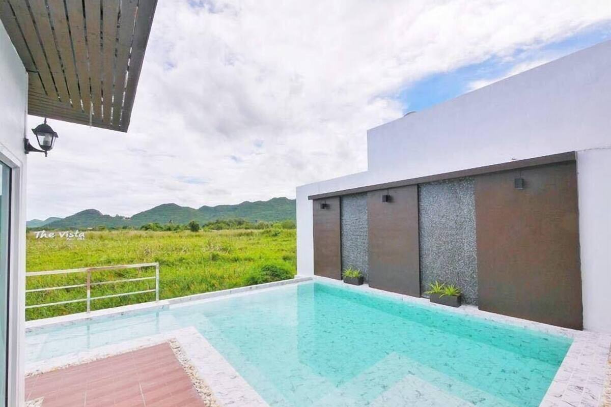 A modern outdoor swimming pool with a clear view of the surrounding landscape.