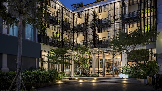 Een modern hotel met een binnentuin, balkons en zitgedeeltes.