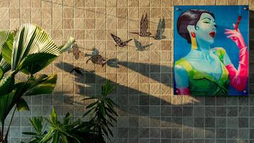 A tiled wall with a mural of a woman and birds.