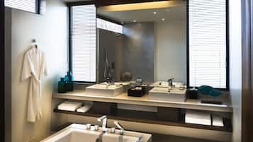 Un baño moderno con dos lavamanos, una bañera y un espejo grande.