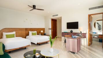 A hotel room with two beds, a desk, a television, and a ceiling fan.