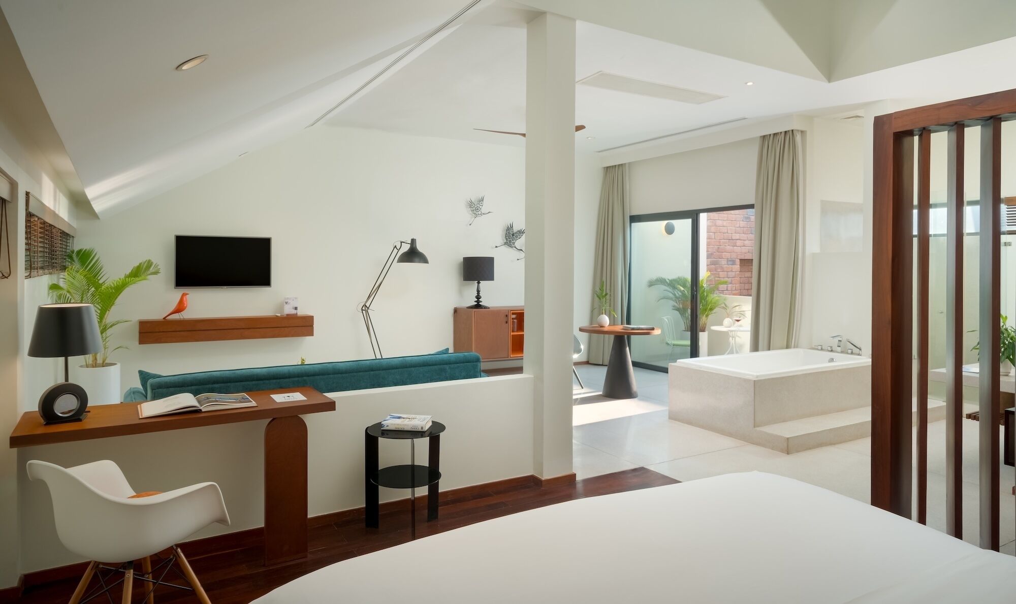 Une chambre d’hôtel moderne dotée d’un grand lit, d’un bureau, d’un canapé, d’une télévision et d’un balcon avec vue.
