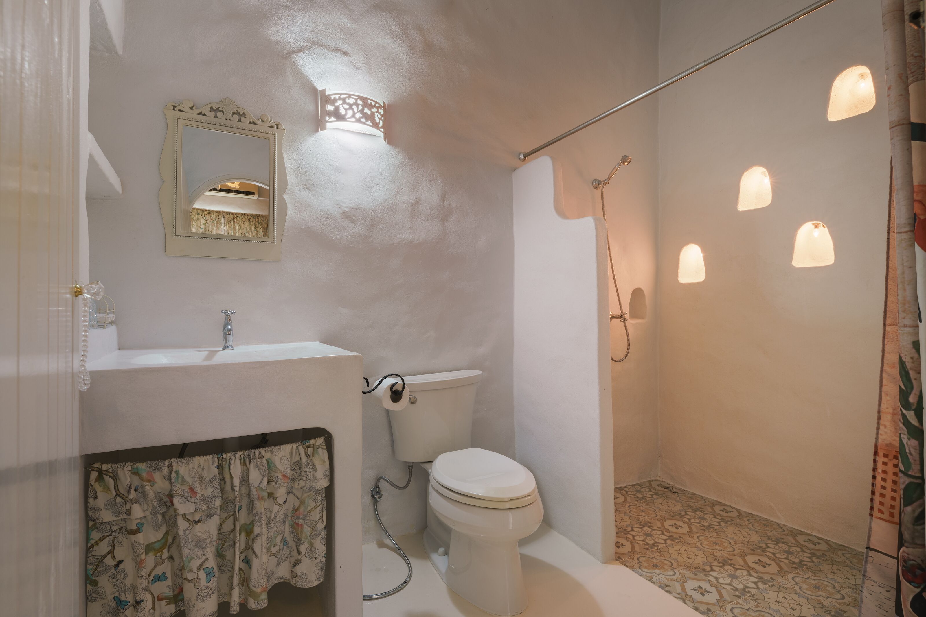 A bathroom with a toilet, sink, and shower.