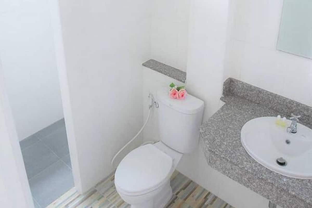 A small, clean bathroom with a toilet, sink, and shower.