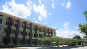 A modern building with multiple floors, large windows, and a covered outdoor area. - BH Place Apartment (Kanchanaburi)