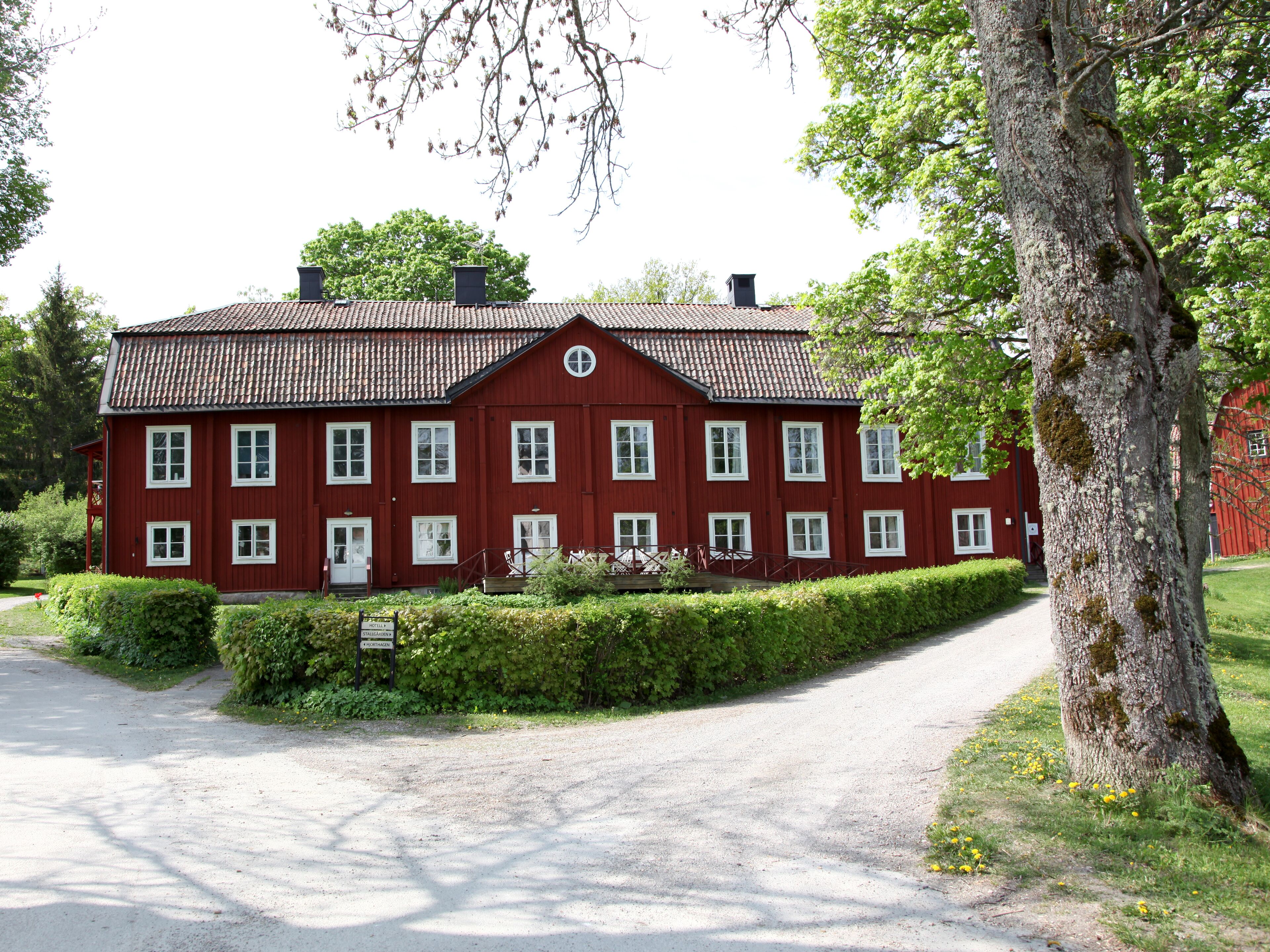 A red building with multiple windows and a covered porch.
