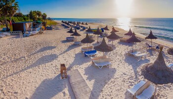 En la playa, sillas reclinables de playa, sombrillas, bar en la playa