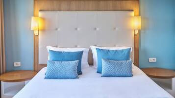 A hotel room with a large bed, two bedside tables, and a headboard with a light wood finish.