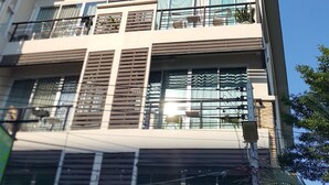 Um edifício com várias andares, varandas, janelas amplas e um telhado plano.