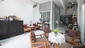 Uma sala de estar ampla, com uma janela grande, uma mesa de jantar e várias cadeiras.