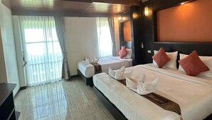 A hotel room with a large bed, a smaller bed, a desk, and a sliding glass door leading to a balcony. - The Sea At Lanta Hotel (Ko Lanta)