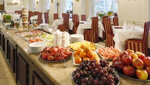Een buffet met verschillende soorten fruit en groenten, zoals appels, sinaasappels en druiven.