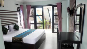 A hotel room with a bed, a desk, and a view of the outside. - VIBOLA Guesthouse (Kampot)