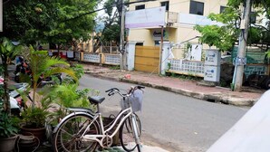 A bicycle parked on a sidewalk next to potted plants. - VIBOLA Guesthouse (Kampot)