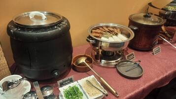 A buffet setup with various food items and utensils.