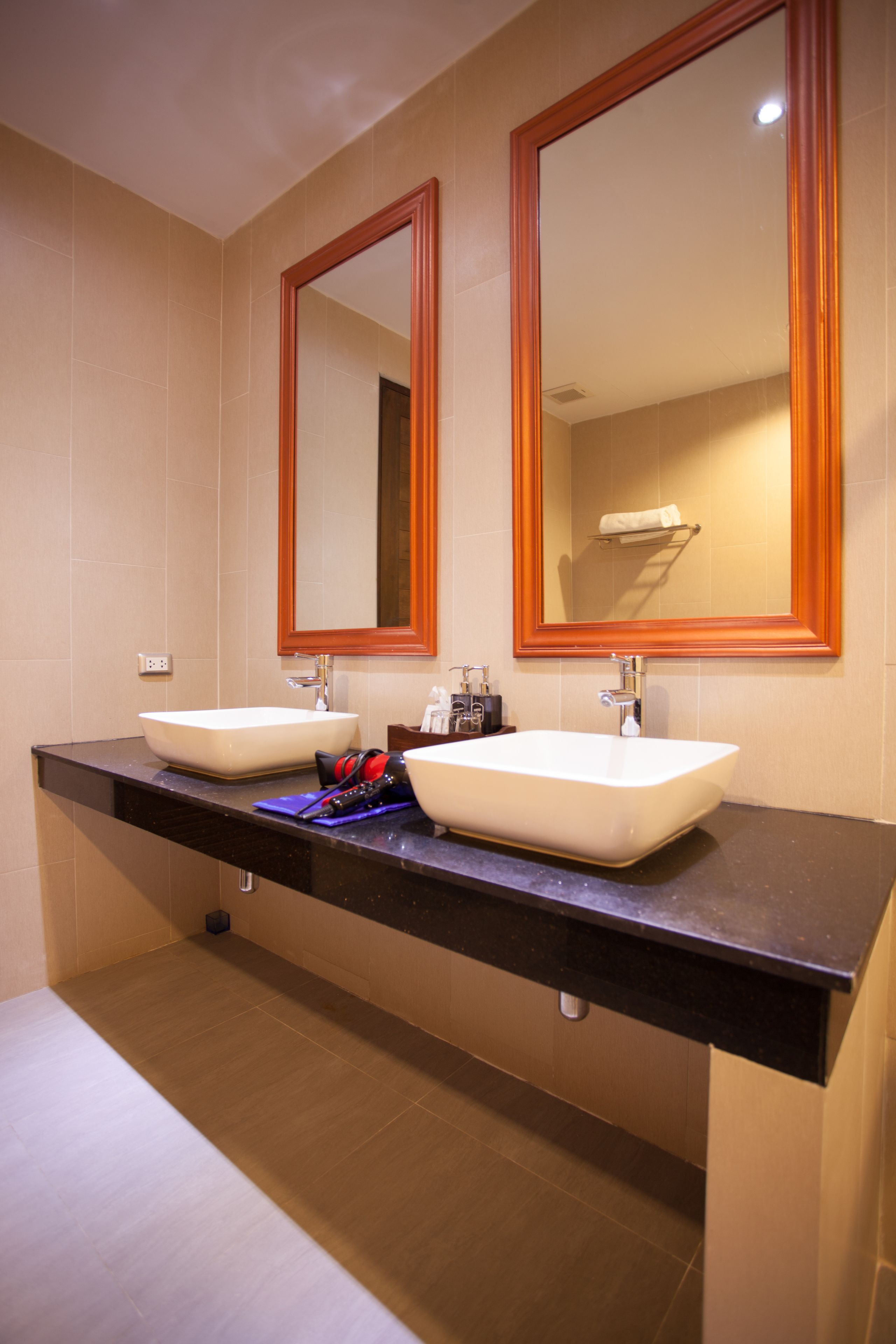 Een badkamer met twee wasbakken, een spiegel en een handdoekhouder.
