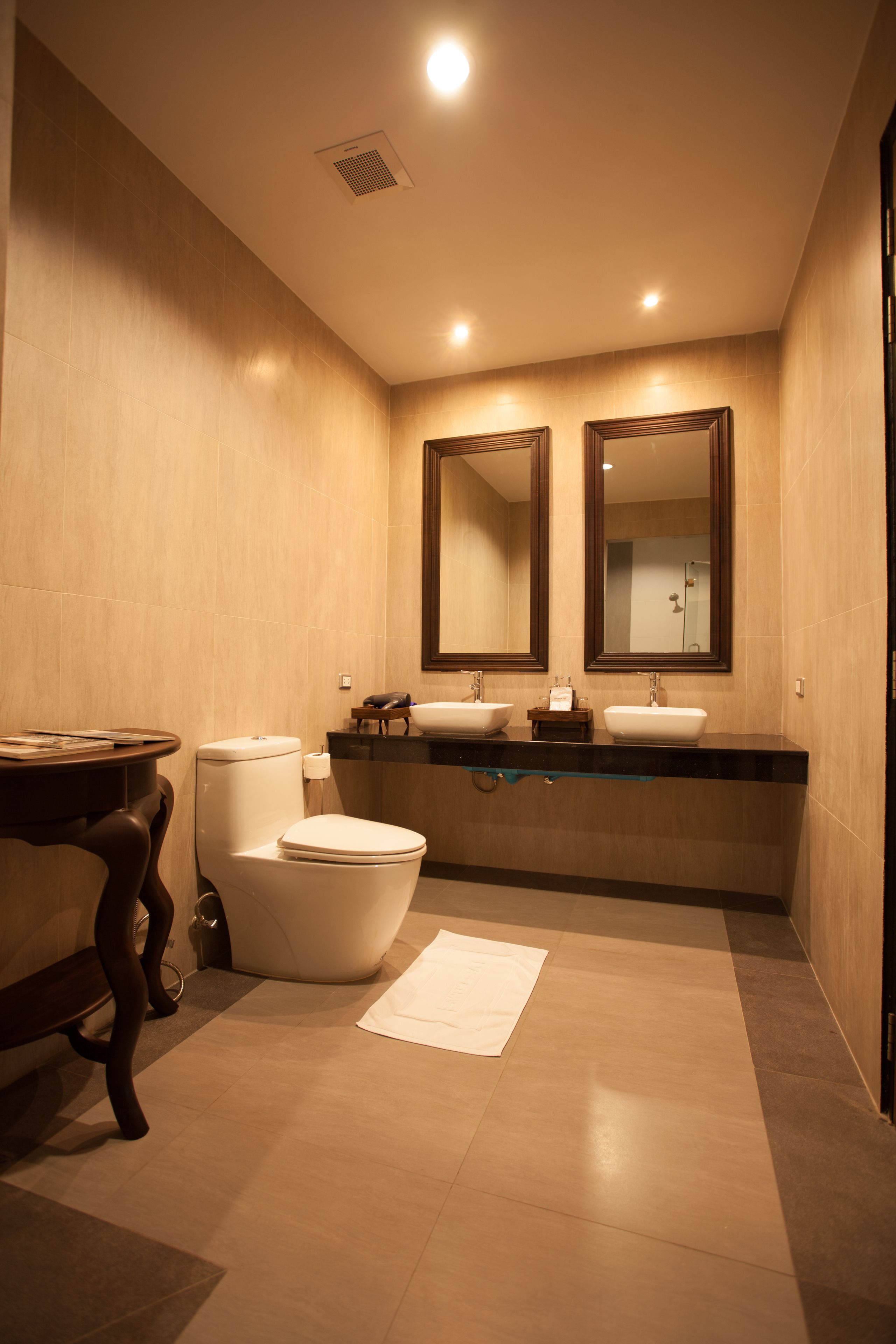 A modern bathroom with a toilet, bidet, and two sinks.