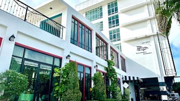 A modern hotel with a white facade, large windows, and a sign indicating it is The Bridge.