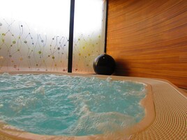 Un jacuzzi con pared de madera y un accesorio de iluminación decorativo.
