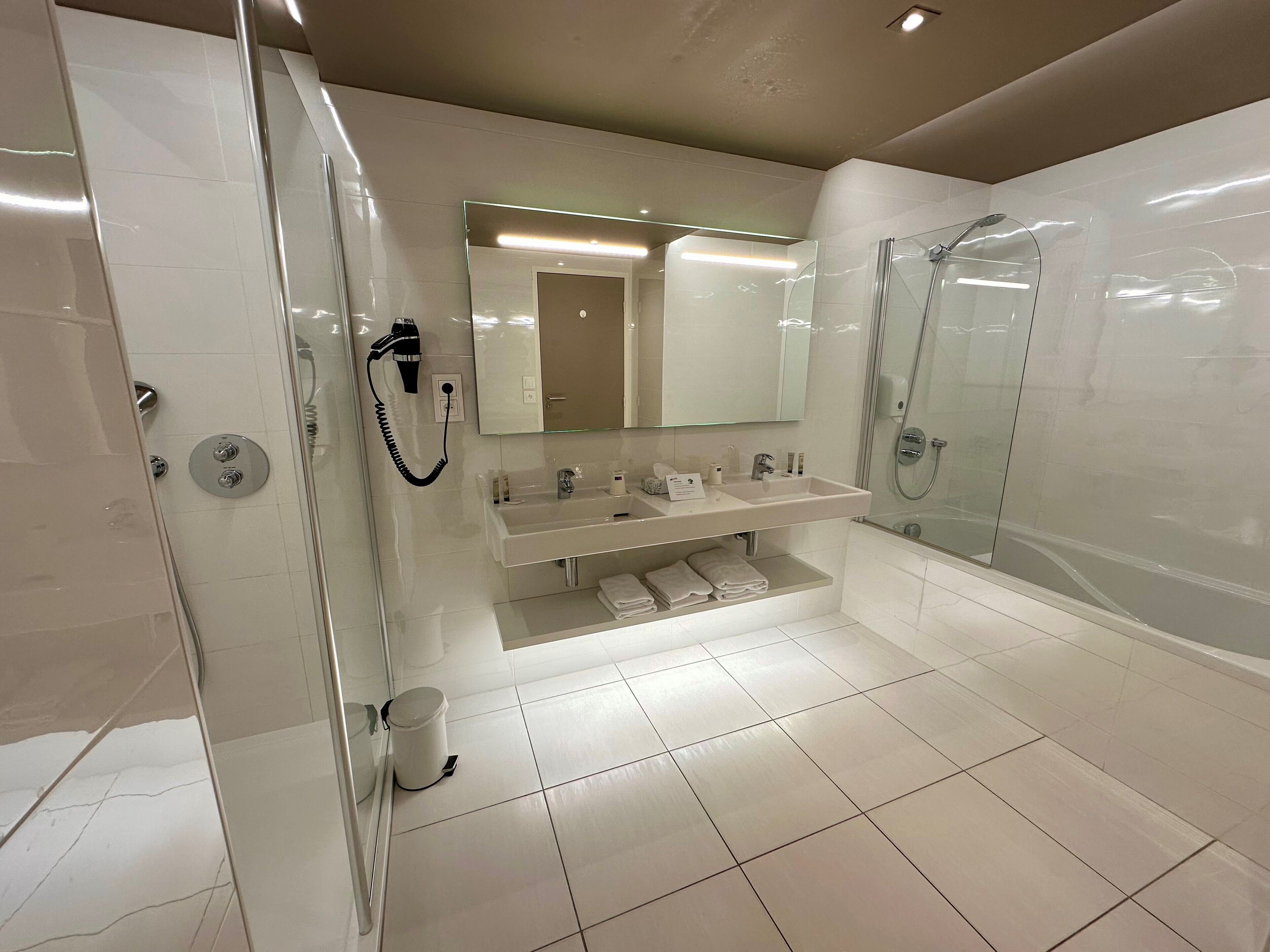 Une salle de bain moderne avec une douche à parois de verre, un meuble-lavabo avec un miroir et des toilettes.