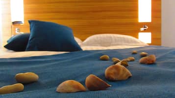 Una cama con un edredón azul y varias piedras encima.
