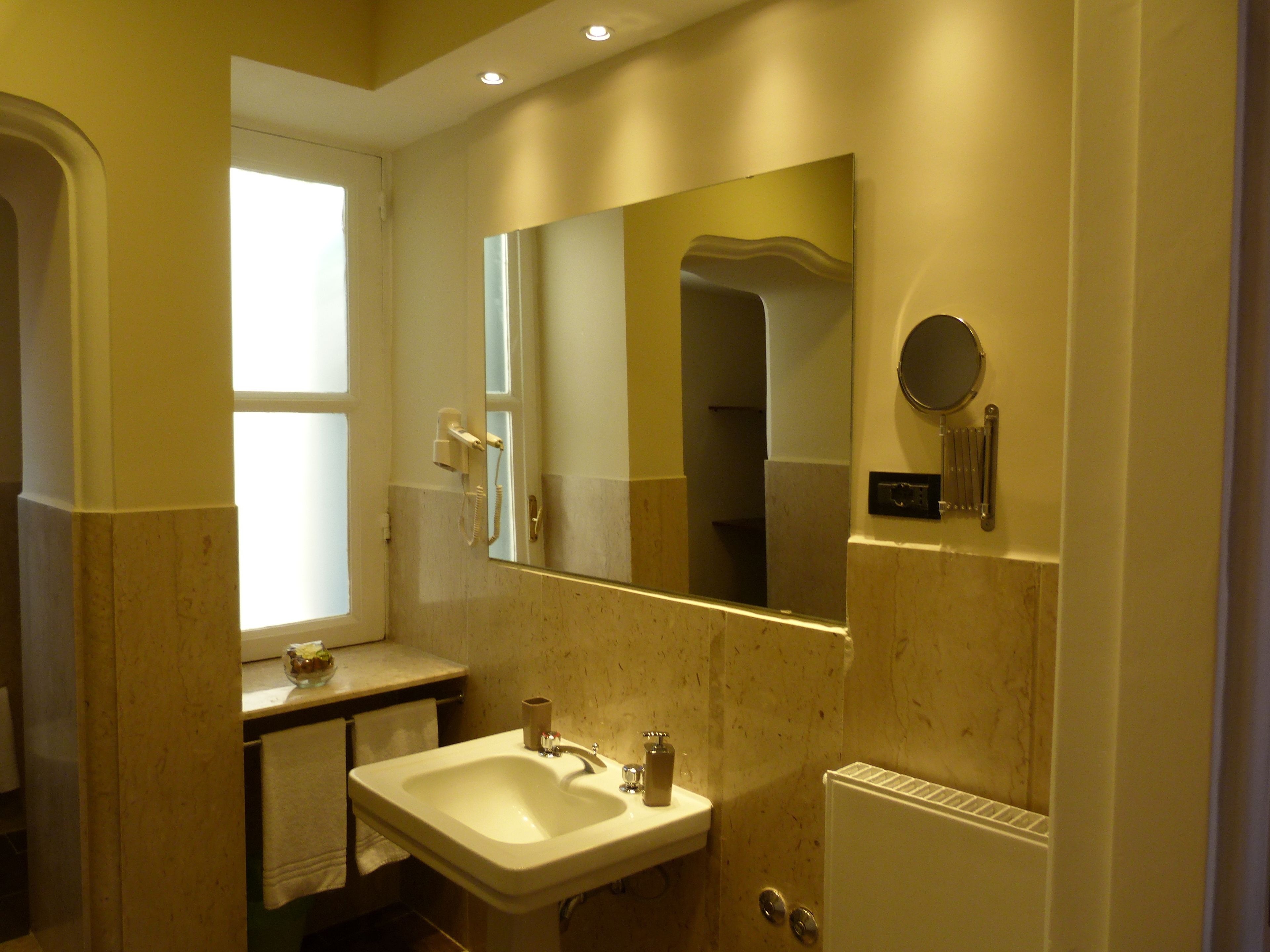 A bathroom with a sink, mirror, and toilet.