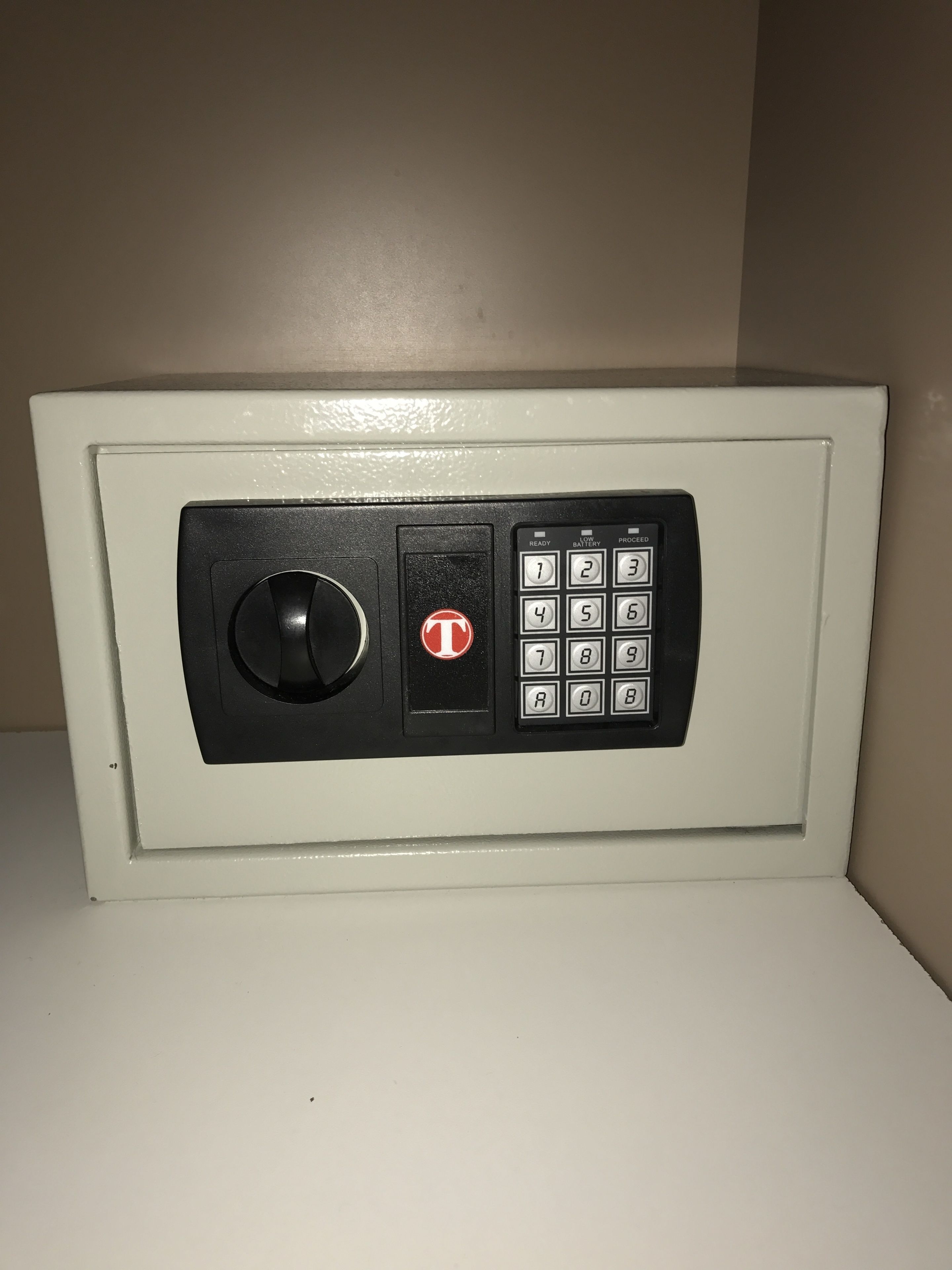 A white safe with a black keypad and a circular lock mechanism.