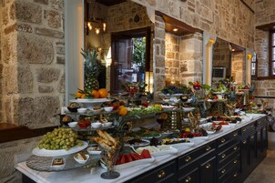 Un bufé con una variedad de frutas, verduras y panes.