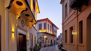 A narrow cobblestone street lined with historic buildings, a boutique hotel with a sign reading "1207", and a parked motorcycle. - Hotel 1207 Special Class (Antalya)