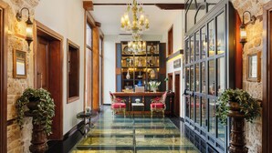 A grand hallway with a glass floor, wooden doors, and a chandelier. - Hotel 1207 Special Class (Antalya)