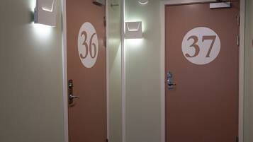 Un pasillo con puertas numeradas 36 y 37, cada una con una lámpara arriba.