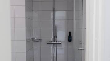 Ducha moderna con cabezal de ducha de mano y grifo empotrado.