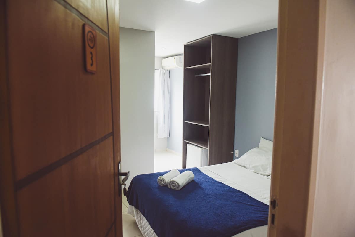 Ein Hotelzimmer mit Bett, Kleiderschrank und Duschbereich.