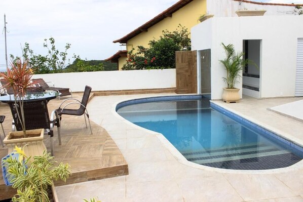 Una piscina al aire libre, tumbonas