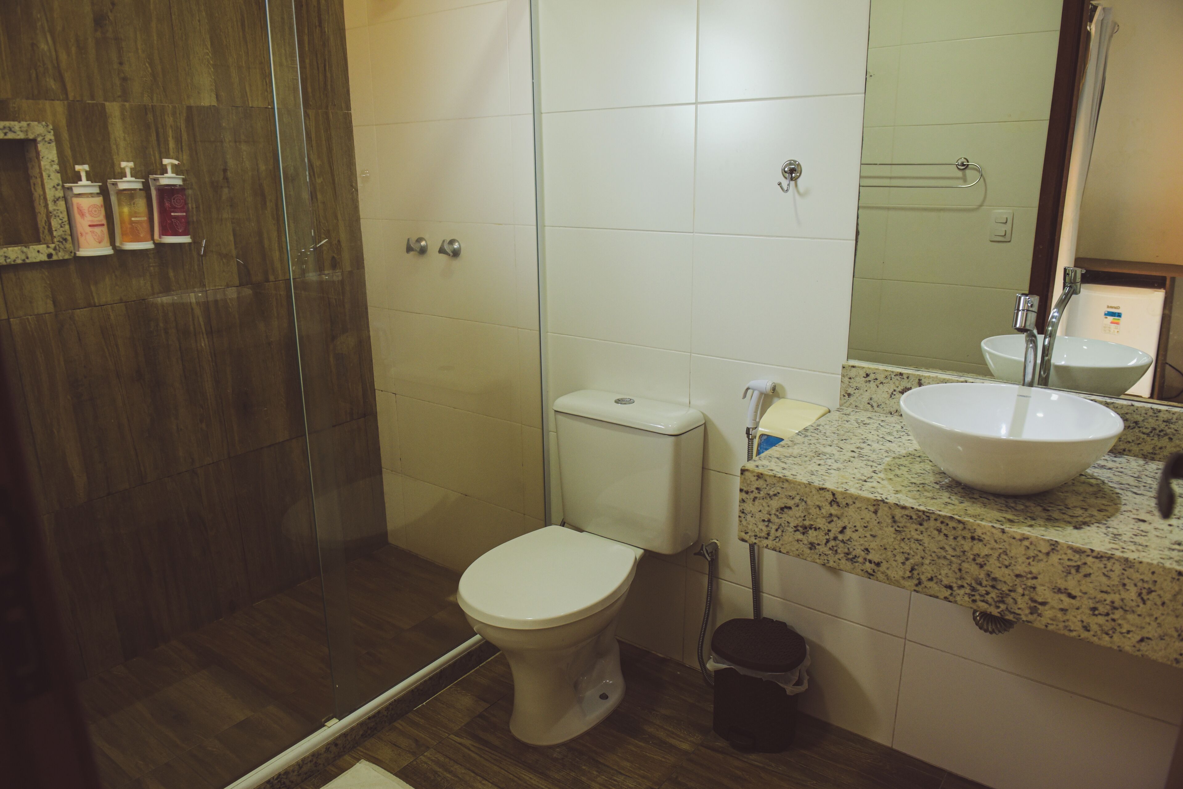 A bathroom with a toilet, sink, and shower.
