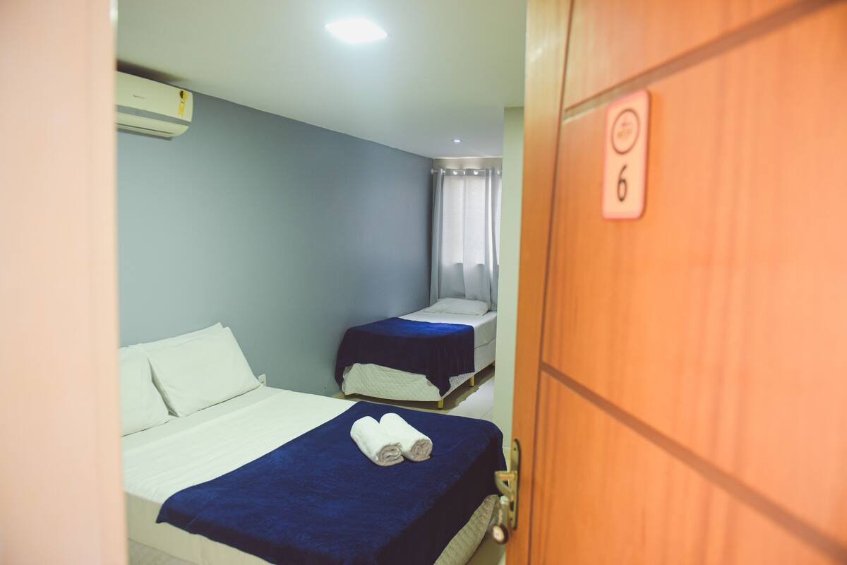 Ein Zimmer mit zwei Betten, einem Deckenventilator und einer Tür mit einer Nummer.