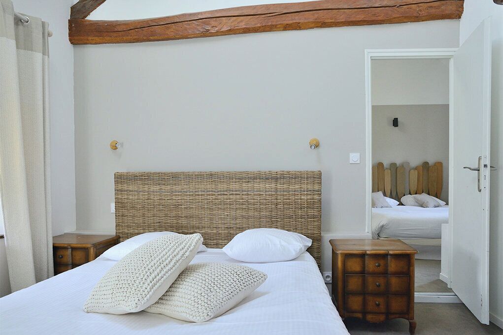 Une chambre à coucher avec un grand lit, deux tables de chevet, une tête de lit en bois et une armoire.