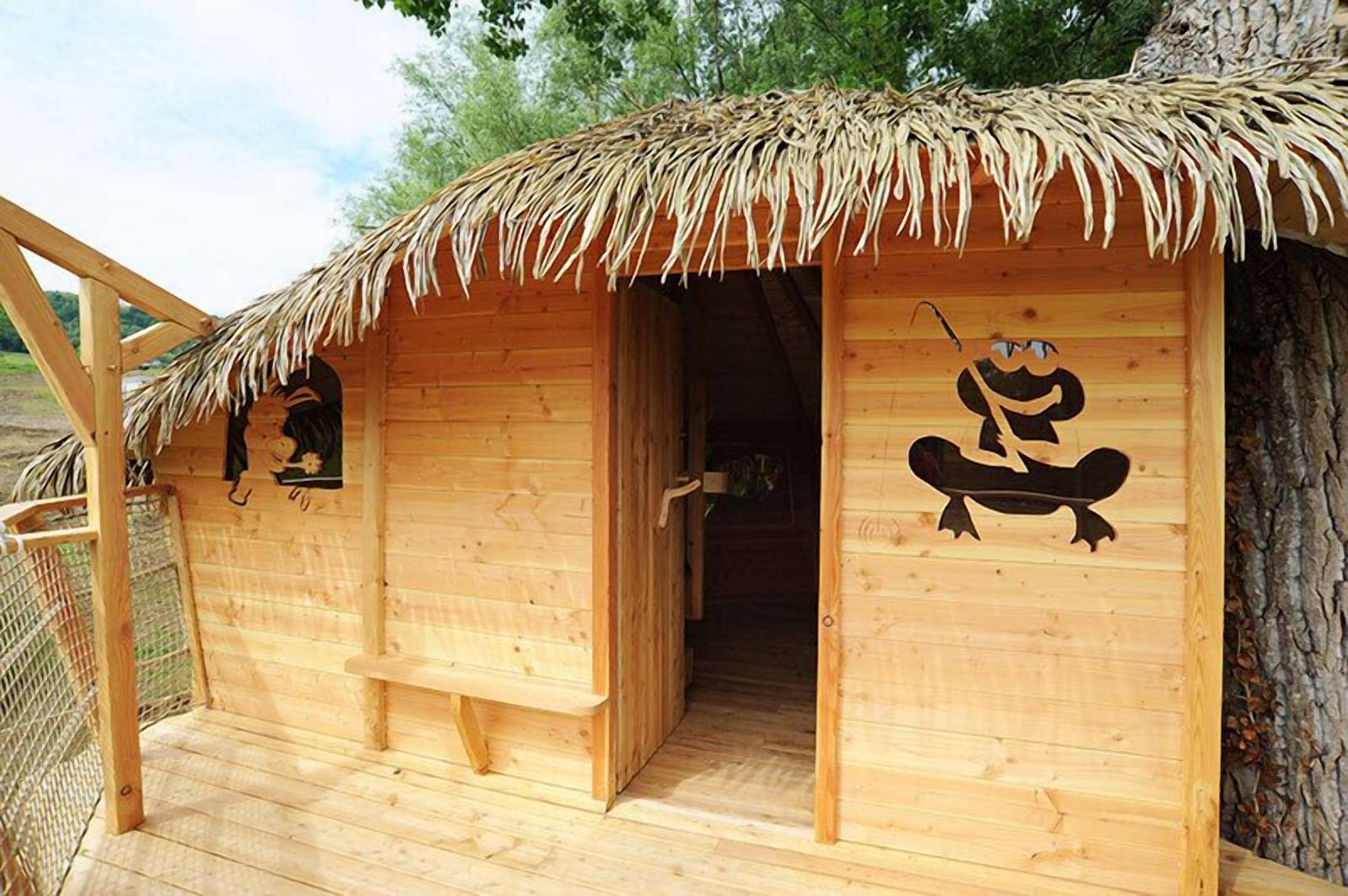 A wooden cabin with a thatched roof, a door, and a window.