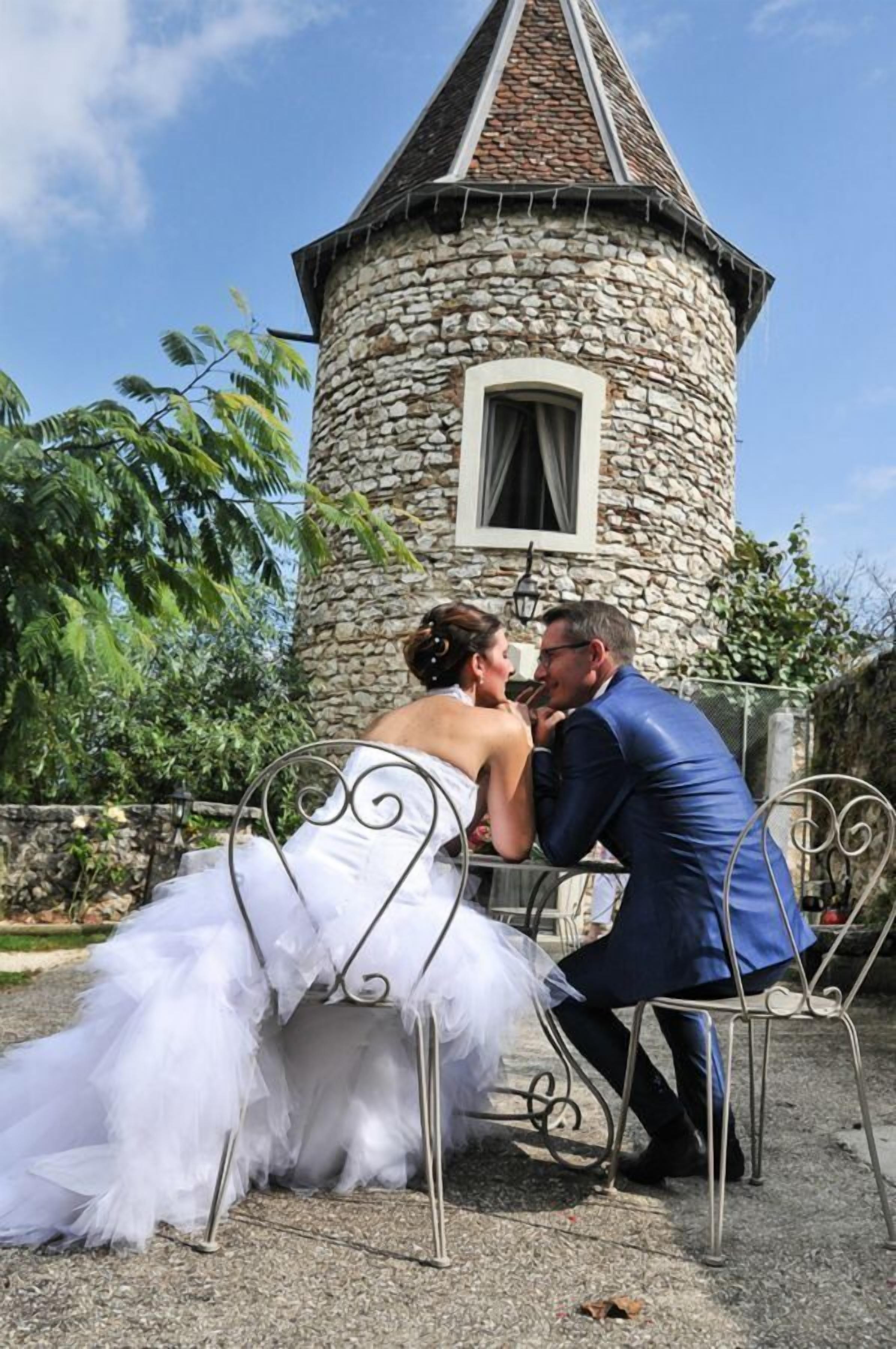 A stone tower with a window and a metal table with chairs.