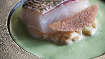 A dish with fish and a garnish on a plate.