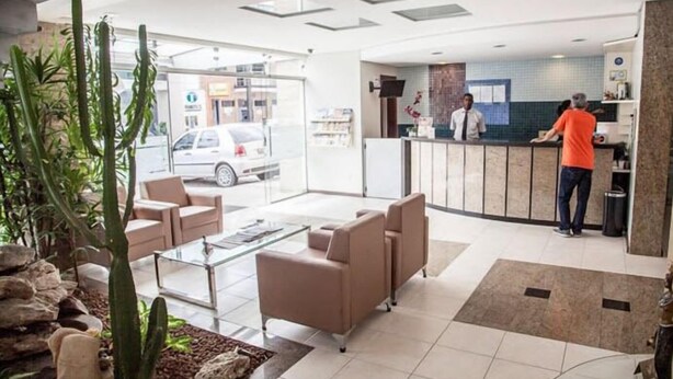 A hotel lobby with seating, a reception desk, and a view of the street. - Portal da Princesa Hotel (Feira de Santana)