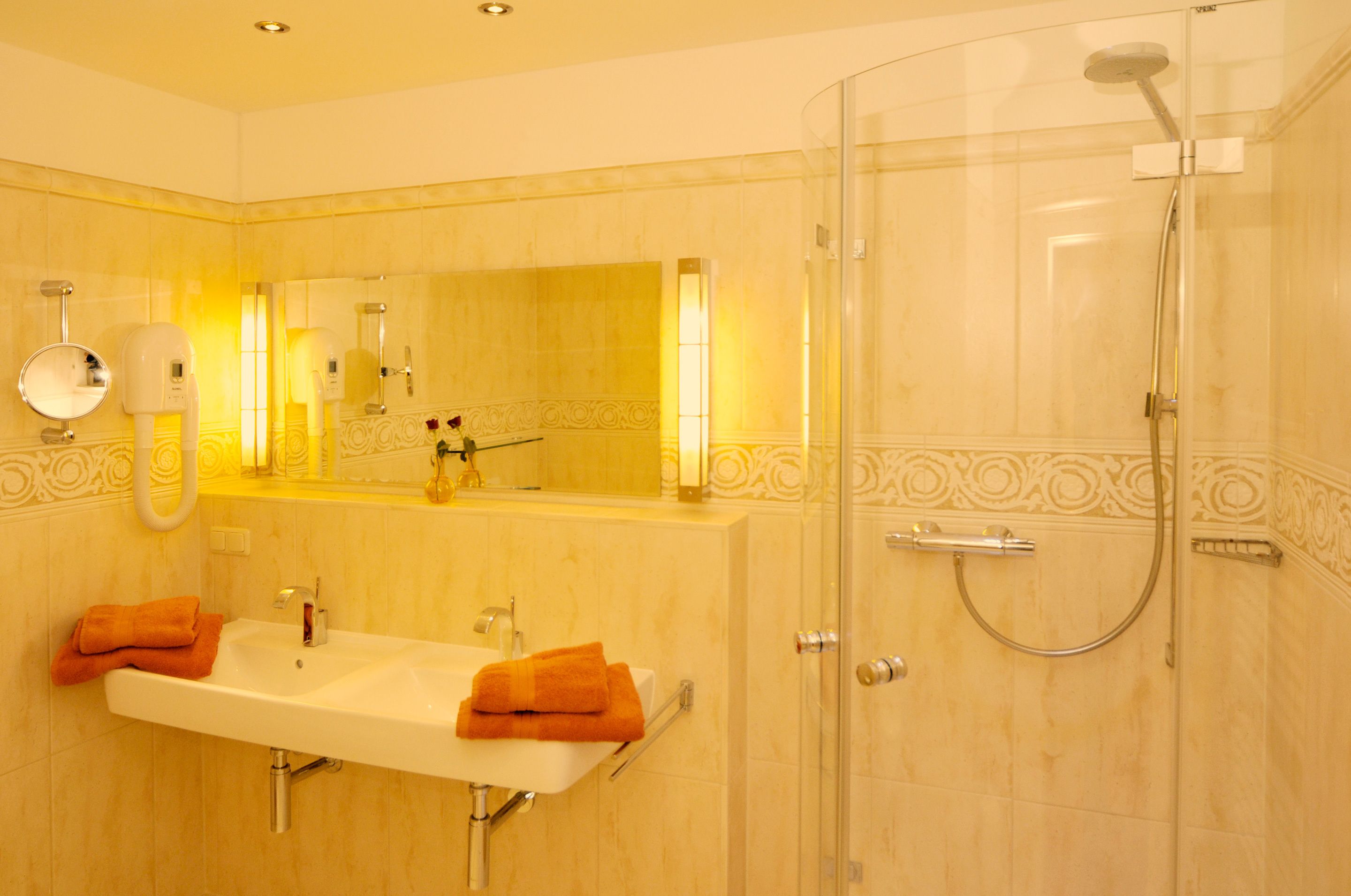 Un bagno con lavandino, specchio e doccia.